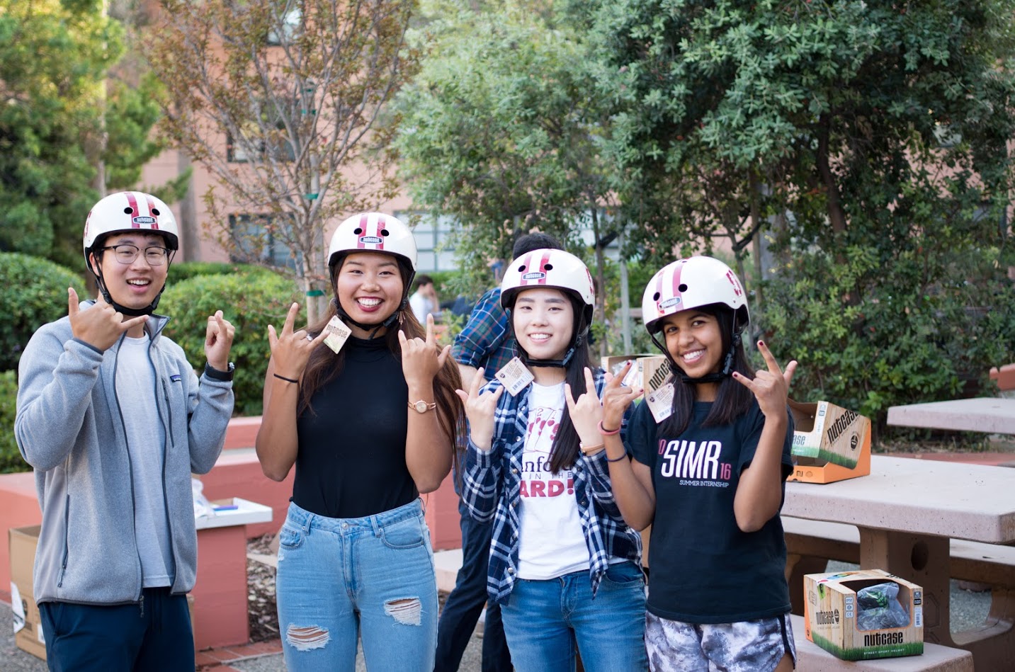 Four smiling students wearing bike helmets