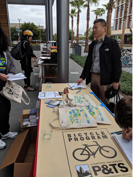 commuter talking with bike to work day volunteers at their table