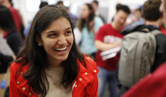 New student in a red jacket attending a Stanford event.