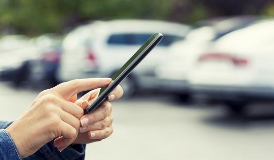 Person using a mobile device in parking lot